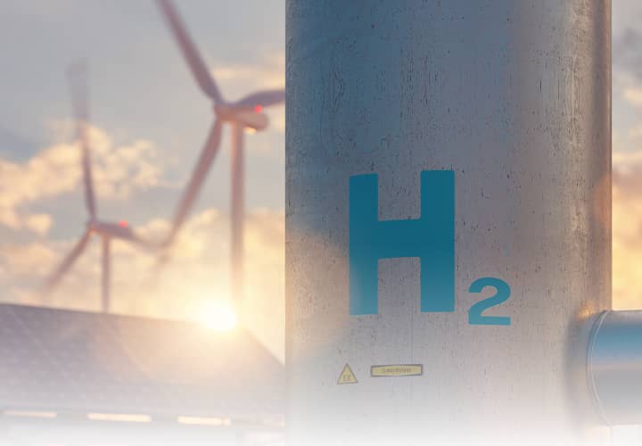 Wasserstoff Anlage mit H2 Kennzeichnung und Windrädern als Symbol für Energiewende und Zukunftstechnologien